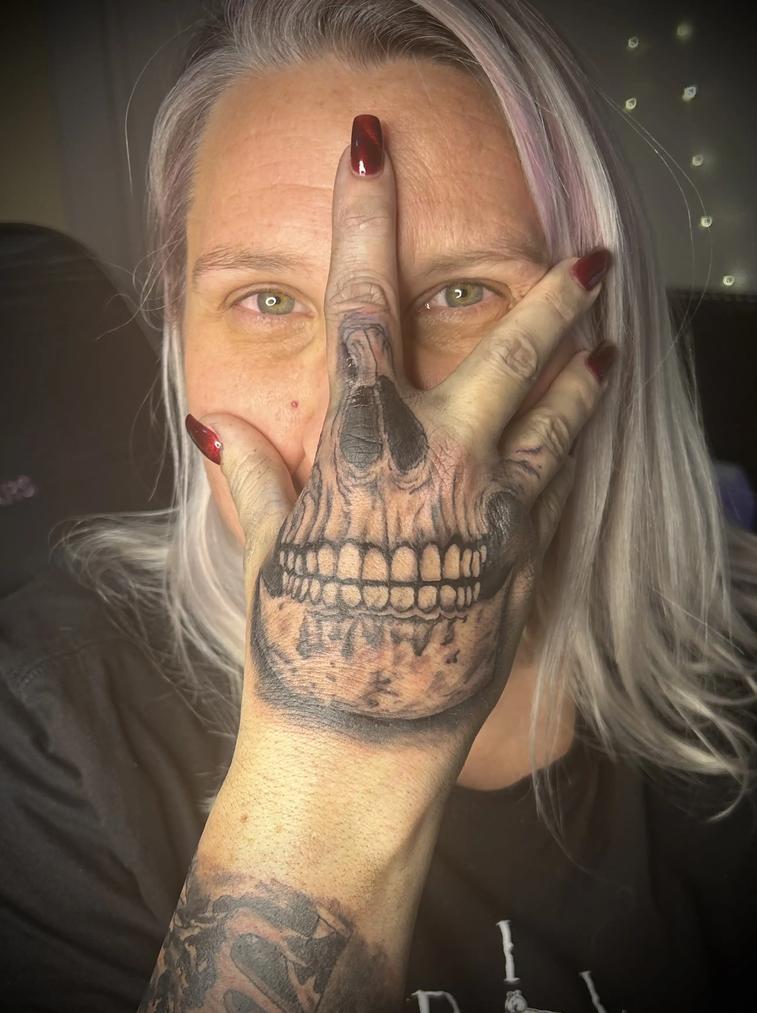 BL-ink Tattoo, Colorado Springs: skull hand tattoo where a realistic skull aligns with the middle finger for a mask illusion