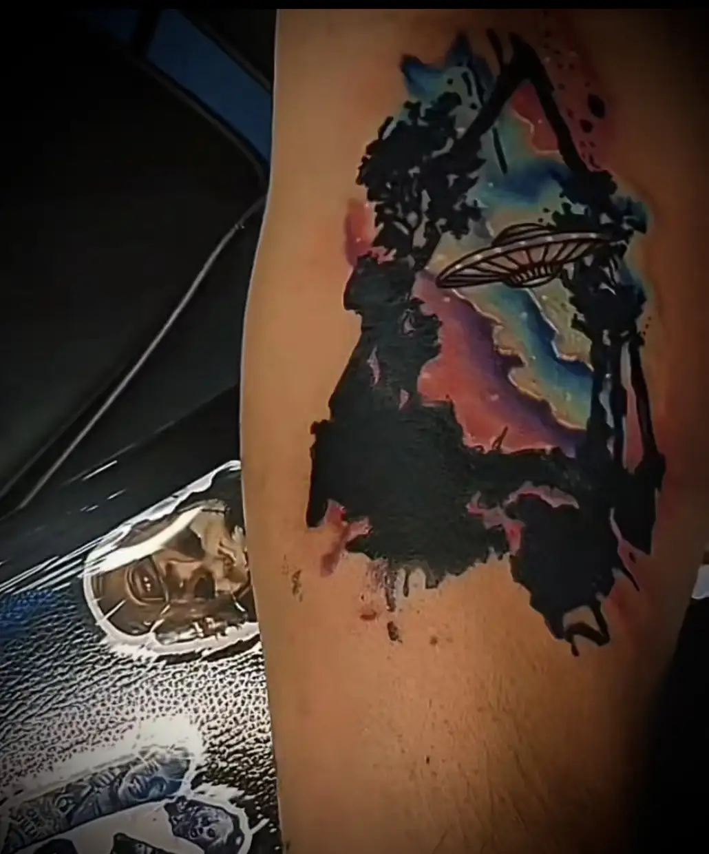 BL-ink Tattoo Colorado Springs UFO watercolor: black forest silhouette and flying saucer over nebula sky