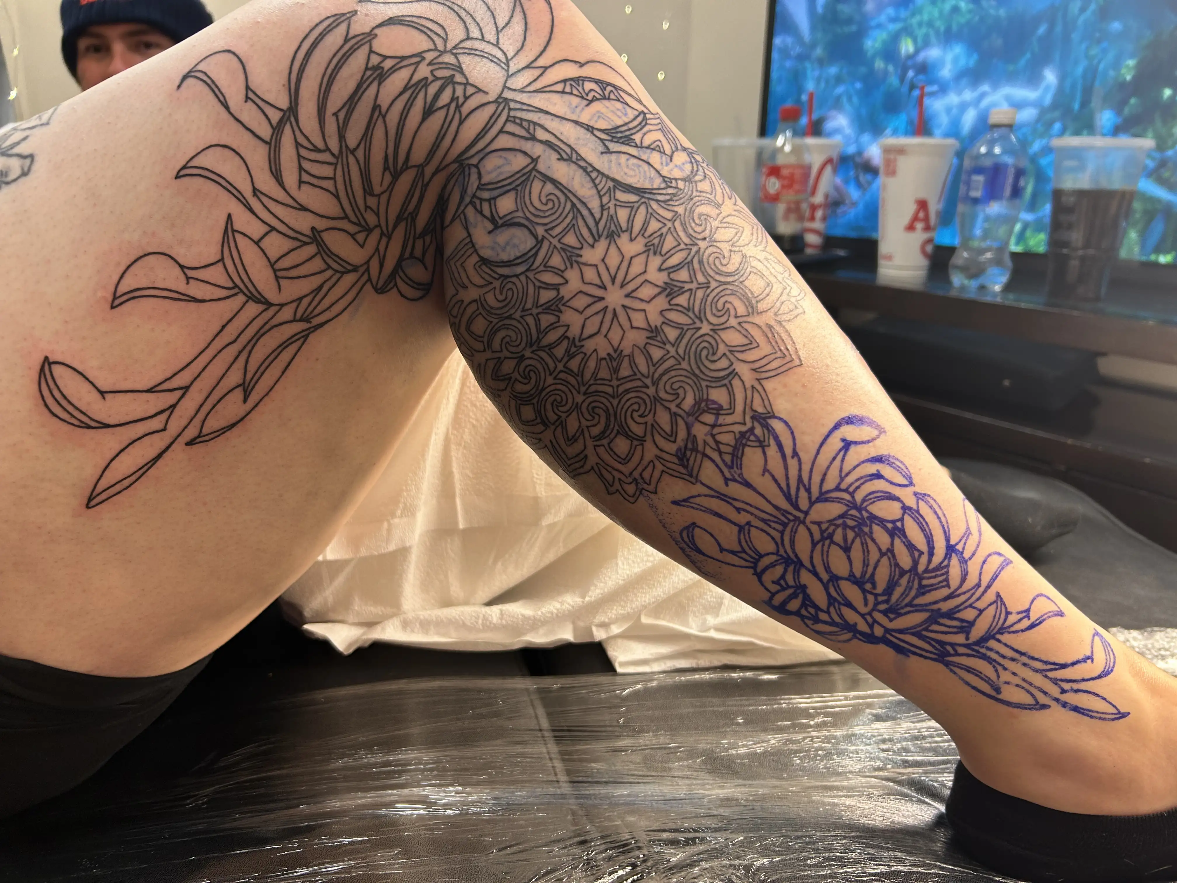 BL-ink Tattoo Colorado Springs leg-sleeve outline: flowing chrysanthemum flowers and a geometric mandala pattern wrapping from upper thigh to ankle.